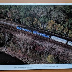Promotional photo: A unit train of grain cars on Conrail's mainline bordering the Mohawk River in New York.
