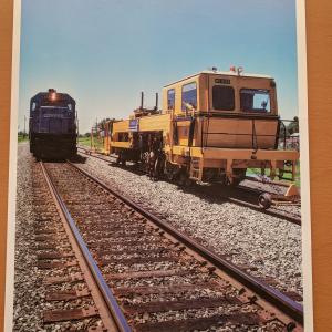 Promotional photo: An SD40-2 passes a continuous action tamper (CAT), used for compacting ballast under railroad ties. Conrail was the first U.S. railroad to use CAT equipment, which increases maintenance productivity.