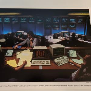 Promotional photo: Computer Assisted Train Dispatching (CATD) provides dispatchers with visual displays of train movements (background) for safer, more efficient train operations.