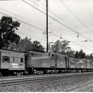 Photograph of GG1 4815 and GG1 4838 shoving against N-7E caboose 21160 on the back of a Morgantown bound coal train in Baltimore MD. 7/3/77