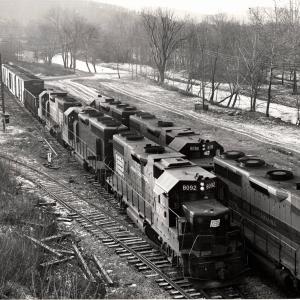 Photograph of GP38-2 8092, GP35 2579, GP38-2 8118 and other units as train JB3 passes train BJ4 at the west end of Allentown Yard. 12/5/76