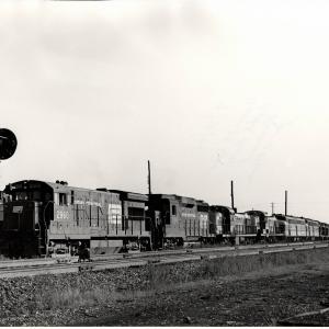 Photograph of U33B 2960, GP30 2199 and a number of other unknown engines on an eastbound light power move at Orrville OH. 7/30/76