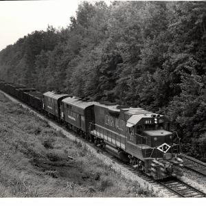 Photograph of GP38AC 311, F7 1683 and another F7 on an empty ore train at Ravenna OH. 7/30/76