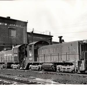 Photograph of SW9 1087 and S4 9744 at E Port Shops. 12/6/76