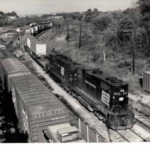 Photograph of GP38-2 8159 and GP9B 3801 on a detouring TV train at the B&O Mt Winans Yard in Baltimore. 9/19/76
