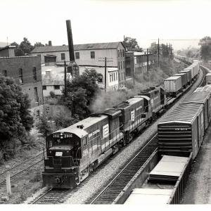 Photograph of U33B 2916, an unknown U30B and a GP35 westbound on TV79 at Waverly NY. 7/3/76