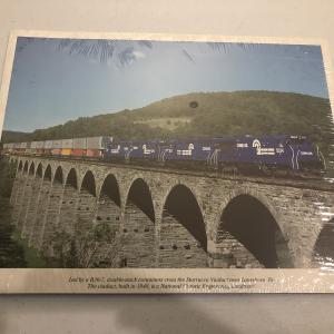 Promotional photo: Led by a B36-7, double-stack containers cross the Starrucca Viaduct near Lanesboro, Pa. The viaduct, built in 1848, is a National Historic Engineering Landmark. (shrink wrapped packet)