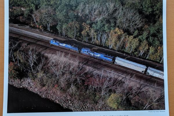 Promotional photo: A unit train of grain cars on Conrail's mainline bordering the Mohawk River in New York.