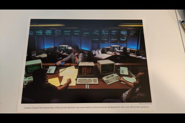 Promotional photo: Computer Assisted Train Dispatching (CATD) provides dispatchers with visual displays of train movements (background) for safer, more efficient train operations.