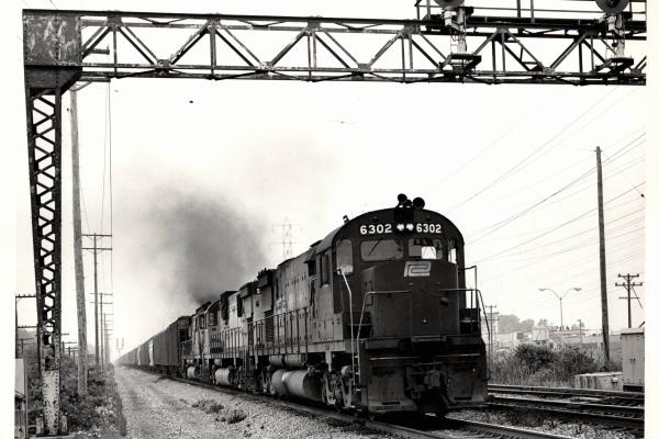Photograph of C628 6302 and other Alco Centuries on an eastbound grain train out of Cleveland OH. 7/31/76