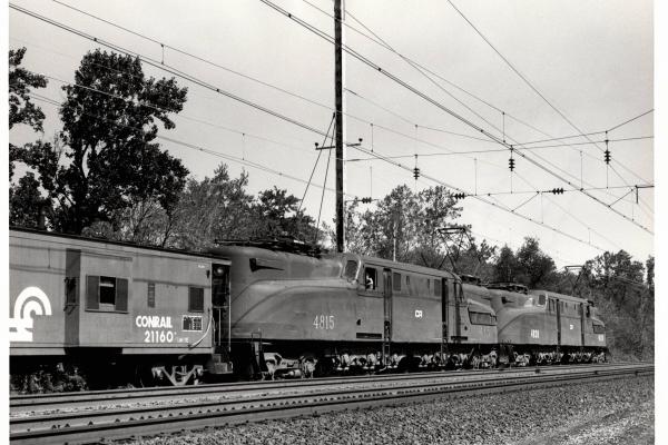 Photograph of GG1 4815 and GG1 4838 shoving against N-7E caboose 21160 on the back of a Morgantown bound coal train in Baltimore MD. 7/3/77