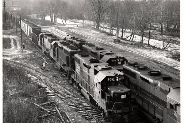 Photograph of GP38-2 8092, GP35 2579, GP38-2 8118 and other units as train JB3 passes train BJ4 at the west end of Allentown Yard. 12/5/76