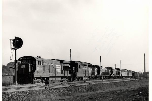 Photograph of U33B 2960, GP30 2199 and a number of other unknown engines on an eastbound light power move at Orrville OH. 7/30/76