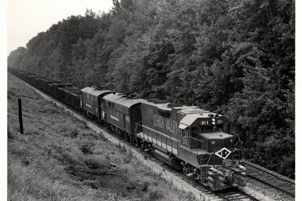 Photograph of GP38AC 311, F7 1683 and another F7 on an empty ore train at Ravenna OH. 7/30/76
