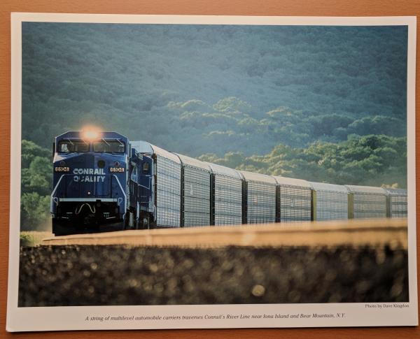 Promotional photo: A string of multilevel automobile carriers traverses Conrail's River Line near Iona Island and Bear Mountain, N.Y.