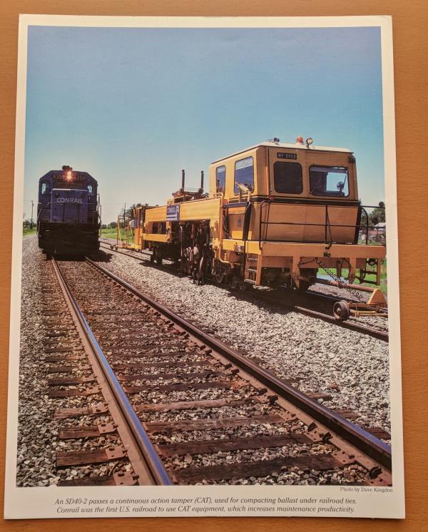 Promotional photo: An SD40-2 passes a continuous action tamper (CAT), used for compacting ballast under railroad ties. Conrail was the first U.S. railroad to use CAT equipment, which increases maintenance productivity.