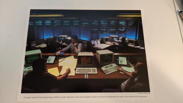 Promotional photo: Computer Assisted Train Dispatching (CATD) provides dispatchers with visual displays of train movements (background) for safer, more efficient train operations.