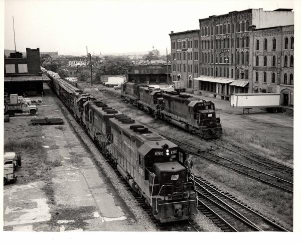 Photograph of SD45 6180, an unknown SD45 and GP38-2 8127 leading train JM-4 at Binghamton NY. SD45 8112, GP38 7956 and an unknown U23B are shown in the background. 9/26/76