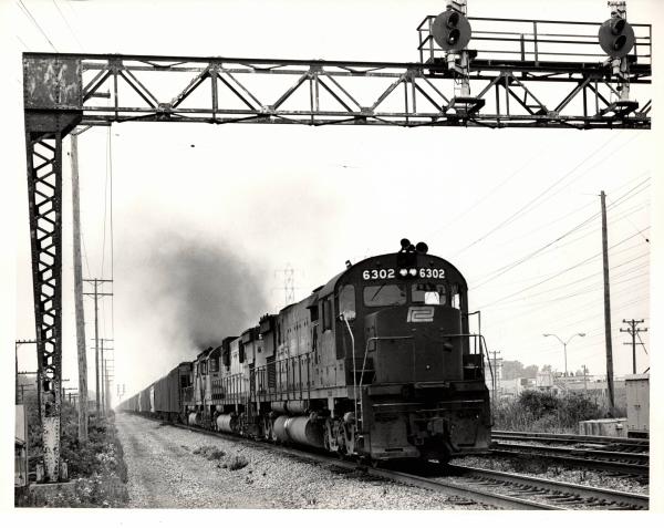 Photograph of C628 6302 and other Alco Centuries on an eastbound grain train out of Cleveland OH. 7/31/76