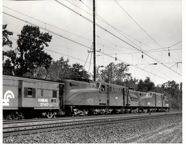 Photograph of GG1 4815 and GG1 4838 shoving against N-7E caboose 21160 on the back of a Morgantown bound coal train in Baltimore MD. 7/3/77