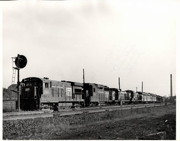 Photograph of U33B 2960, GP30 2199 and a number of other unknown engines on an eastbound light power move at Orrville OH. 7/30/76