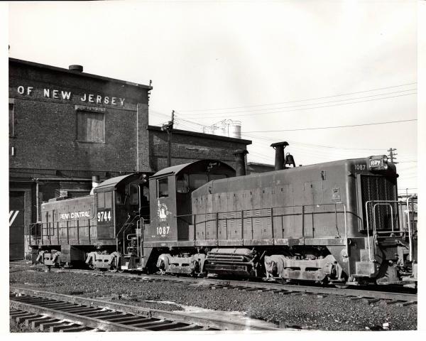 Photograph of SW9 1087 and S4 9744 at E Port Shops. 12/6/76