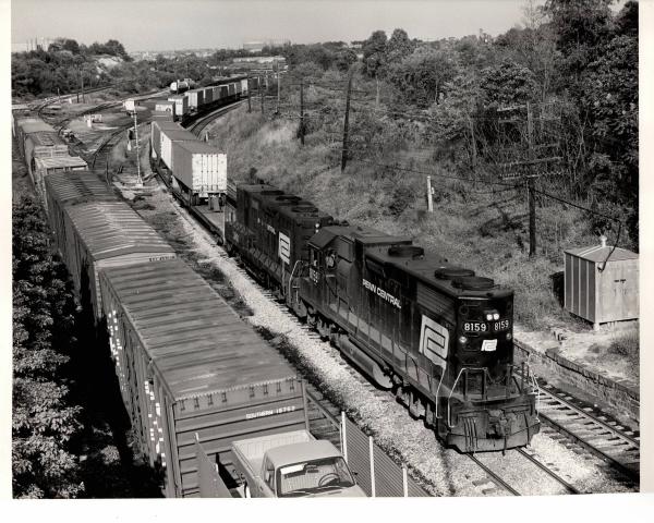 Photograph of GP38-2 8159 and GP9B 3801 on a detouring TV train at the B&O Mt Winans Yard in Baltimore. 9/19/76