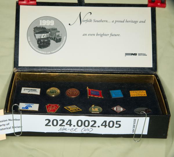 Black box containing lapel pins for NS, NS predecessors, CR and CR predecessors; Norfolk Southern...a proud heritage and an even brighter future