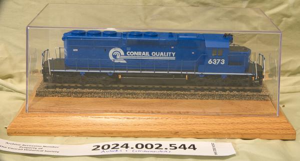 HO gauge SD40-2 #6373 on wooden base inside clear plastic case.