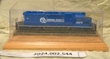 HO gauge SD40-2 #6373 on wooden base inside clear plastic case.